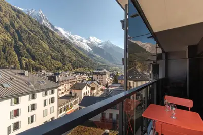a balcony with a view of a city and mountains at Appt Cosy - Vue Mont-Blanc en hyper centre in Chamonix-Mont-Blanc