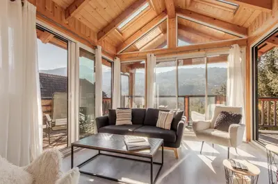 a living room with a couch and a table at Au coin du feu - Terrasse - Vue Mont Blanc in Saint-Gervais-les-Bains