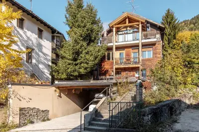 a house in the mountains with stairs leading up to it at Au coin du feu - Terrasse - Vue Mont Blanc in Saint-Gervais-les-Bains