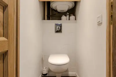 a bathroom with a white toilet and a mirror at Au coin du feu - Terrasse - Vue Mont Blanc in Saint-Gervais-les-Bains