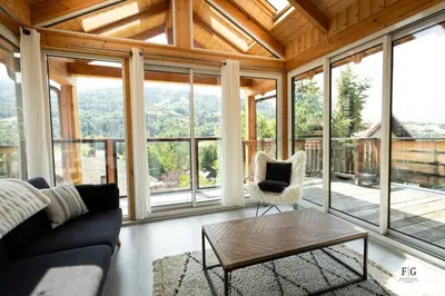 a living room with a couch and a table at Au coin du feu - Terrasse - Vue Mont Blanc in Saint-Gervais-les-Bains