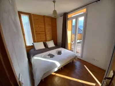 a bedroom with a bed and a large window at Au coin du feu - Terrasse - Vue Mont Blanc in Saint-Gervais-les-Bains