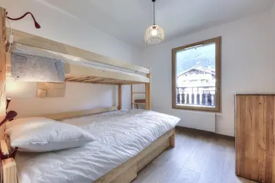 a bedroom with a bunk bed and a window at Mountain Lodge 204 - 90m2 - à côté du télésiège in Saint-Gervais-les-Bains