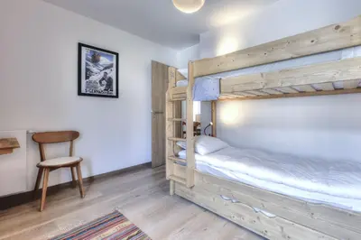 a bedroom with two bunk beds and a chair at Mountain Lodge 204 - 90m2 - à côté du télésiège in Saint-Gervais-les-Bains
