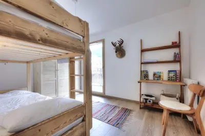 a bedroom with a wooden bunk bed and a window at Mountain Lodge 204 - 90m2 - à côté du télésiège in Saint-Gervais-les-Bains