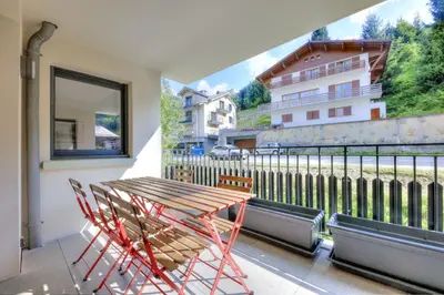 a balcony with a wooden table and chairs at Mountain Lodge 204 - 90m2 - à côté du télésiège in Saint-Gervais-les-Bains