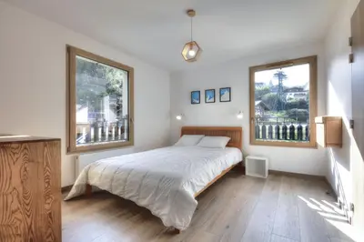 a bedroom with a large bed and two windows at Mountain Lodge 204 - 90m2 - à côté du télésiège in Saint-Gervais-les-Bains