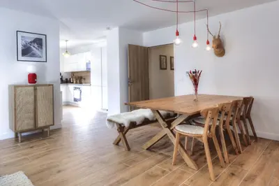 a kitchen and dining room with a wooden table and chairs at Mountain Lodge 204 - 90m2 - à côté du télésiège in Saint-Gervais-les-Bains