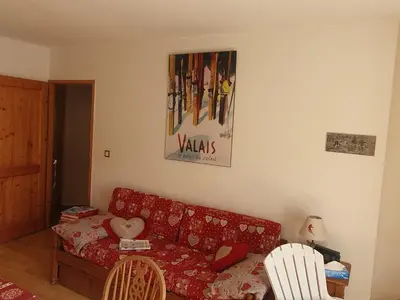 a living room with a red couch and two chairs at APPARTEMENT 6 Personnes SAMOENS in Samoëns