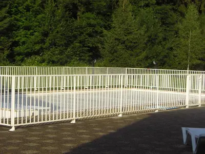 a white fence in front of a park with trees at APPARTEMENT 6 Personnes SAMOENS in Samoëns