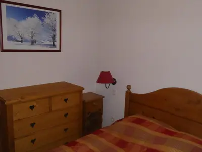 a bedroom with a bed and a dresser and a picture at APPARTEMENT 6 Personnes SAMOENS in Samoëns