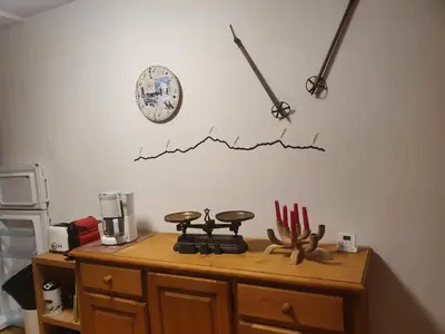 a kitchen counter with a stove and a clock on the wall at APPARTEMENT 6 Personnes SAMOENS in Samoëns