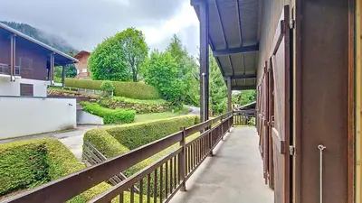 a balcony of a building with a fence and bushes at 1 Gentil Homme in Megève