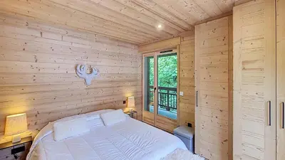 a bedroom with a bed in a wooden wall at 1 Gentil Homme in Megève