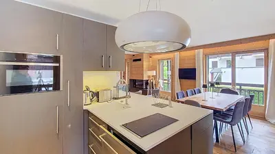 a kitchen with a counter and a table with chairs at 1 Gentil Homme in Megève