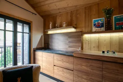 a kitchen with wooden cabinets and a large window at Chalet L'Écrin de Megève in Megève