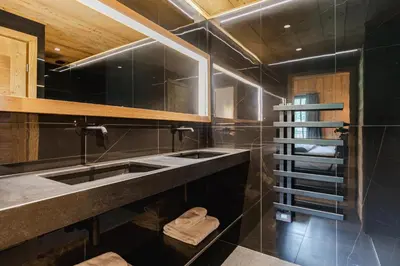 a bathroom with two sinks and a spiral staircase at Chalet L'Écrin de Megève in Megève
