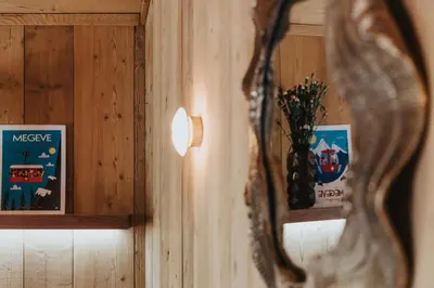 a mirror on a wooden wall with two pictures at Chalet L'Écrin de Megève in Megève