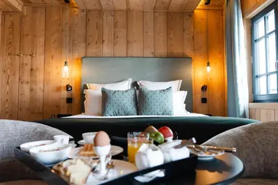 a hotel room with a bed and a table with food at Chalet L'Écrin de Megève in Megève