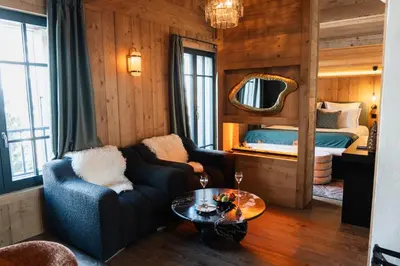 a living room with a couch and a bed at Chalet L'Écrin de Megève in Megève