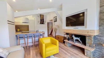 a living room with a fireplace and a yellow chair at 1 Clos des Mourets C2 in Megève