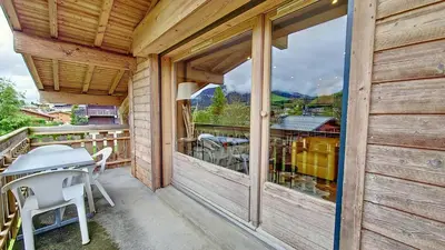 a patio with a table and chairs on a balcony at 1 Clos des Mourets C2 in Megève