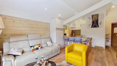 a living room with a white couch and a yellow stool at 1 Clos des Mourets C2 in Megève