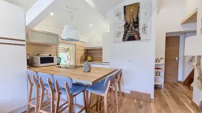 a kitchen with a wooden table and chairs at 1 Clos des Mourets C2 in Megève