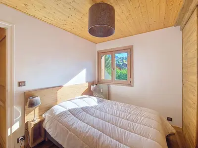 a bedroom with a large bed and a window at 1 Chalet de Rochebrune B in Megève