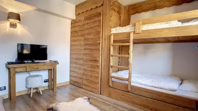 a room with two bunk beds and a desk at 1 Chalet de Rochebrune B in Megève