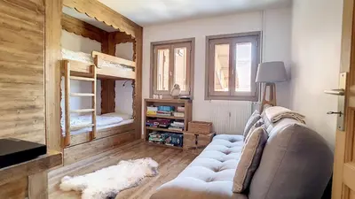 a living room with a couch and two bunk beds at 1 Chalet de Rochebrune B in Megève