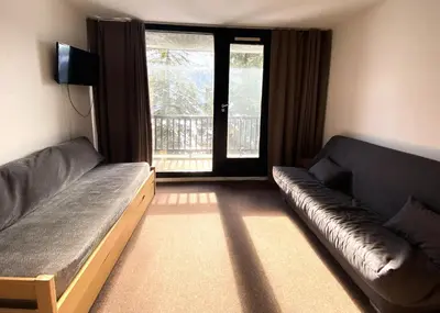 a living room with a couch and a tv and a window at Résidence Capricorne - maeva Home - Studio 4 Personnes - Budget MAE-3836 in Flaine