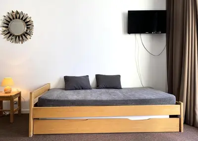 a bedroom with a bed and a mirror on the wall at Résidence Capricorne - maeva Home - Studio 4 Personnes - Budget MAE-3836 in Flaine