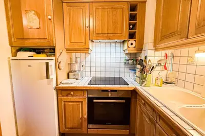 a kitchen with wooden cabinets and a washer at Stay in the heart of Chamonix-Mont-Blanc in Chamonix-Mont-Blanc