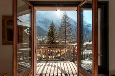 an open door with a view of a snowy mountain at Le Refuge des Pecles, chalet avec vue Mont-Blanc in Chamonix-Mont-Blanc