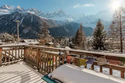 a snow covered balcony with a view of mountains at Le Refuge des Pecles, chalet avec vue Mont-Blanc in Chamonix-Mont-Blanc