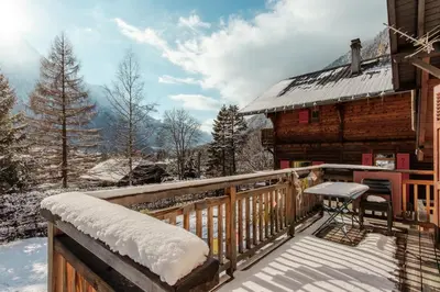 a balcony of a log cabin in the snow at Le Refuge des Pecles, chalet avec vue Mont-Blanc in Chamonix-Mont-Blanc
