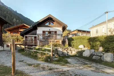 a house in the mountains with a stone wall at Le Refuge des Pecles, chalet avec vue Mont-Blanc in Chamonix-Mont-Blanc