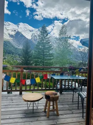 a patio with a table and a view of mountains at Le Refuge des Pecles, chalet avec vue Mont-Blanc in Chamonix-Mont-Blanc