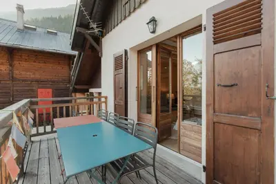 a table on the balcony of a house at Le Refuge des Pecles, chalet avec vue Mont-Blanc in Chamonix-Mont-Blanc