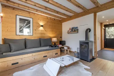 a living room with a couch and a stove at Le Refuge des Pecles, chalet avec vue Mont-Blanc in Chamonix-Mont-Blanc
