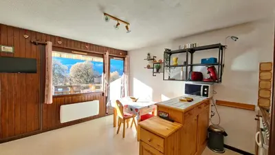 a kitchen with a small table and a window at Appartement Samoens village in Samoëns