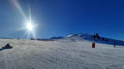 a person riding a snowboard down a snow covered slope at Appartement Samoens village in Samoëns
