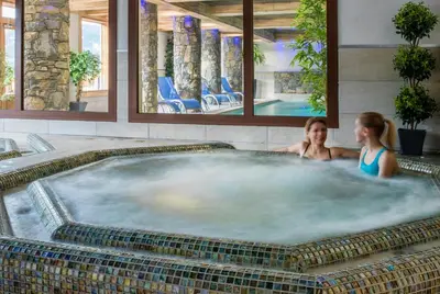 two women in a hot tub in a spa at CGH Résidence Boutique Les Chalets De Laÿssia in Samoëns