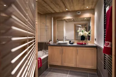 a bathroom with a sink and a mirror at CGH Résidence Boutique Les Chalets De Laÿssia in Samoëns