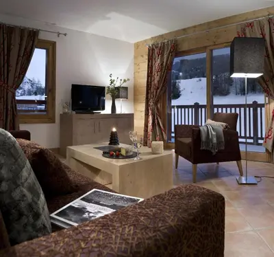 a living room with a couch and a table at CGH Résidence Boutique Les Chalets De Laÿssia in Samoëns