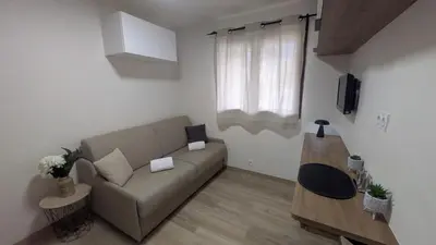 a living room with a couch and a window at Studio La Vallée Blanche in Sallanches