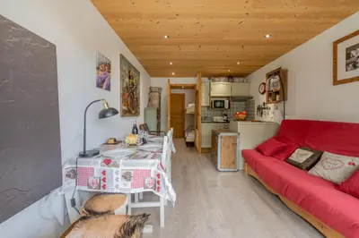 a living room with a red couch and a red table at Clos Du Savoy - South Facing Balcony - Happy Rentals in Chamonix-Mont-Blanc