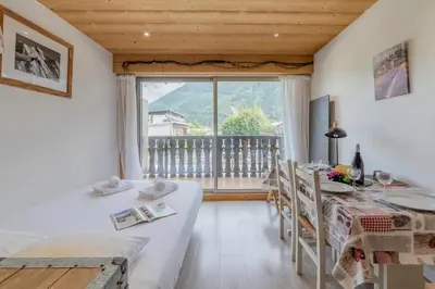 a dining room with a table and a painting on the wall at Clos Du Savoy - South Facing Balcony - Happy Rentals in Chamonix-Mont-Blanc