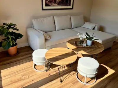 a living room with a couch and two tables and stools at Appartement Champêtre - Terrasse, Vue & Parking by AlpenlySallanches in Domancy